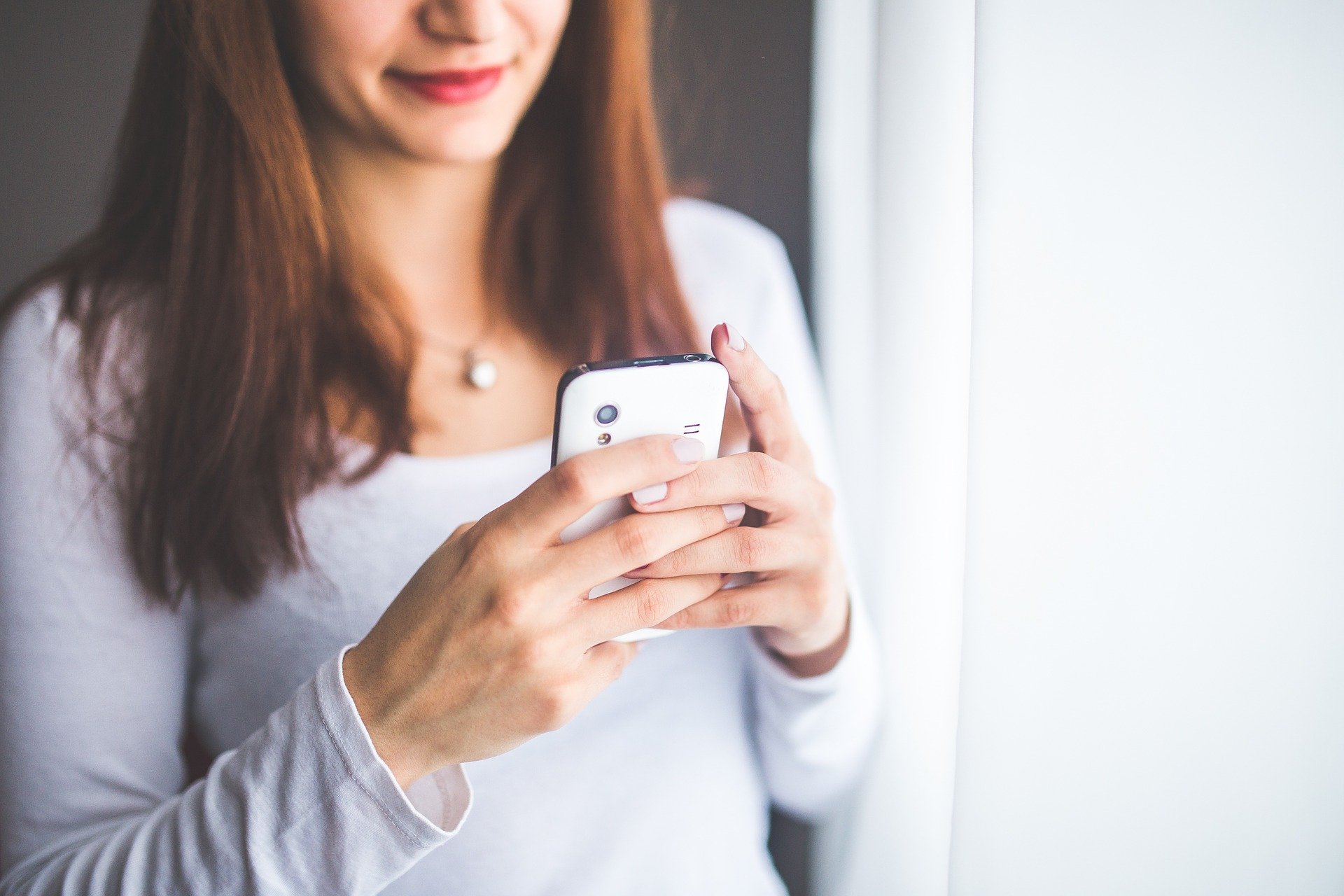 Young woman holding a mobile phone, FaceTime